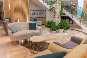 um átrio com sofás, mesas e escadas em MiRaBelle Hotel - Half Board Plus & All Inclusive em Golden Sands