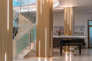 a lobby with a piano and a staircase at MiRaBelle Hotel - Half Board Plus & All Inclusive in Golden Sands