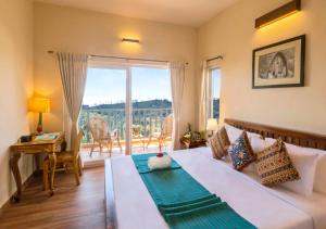 a bedroom with a bed and a desk and a window at Sleeping Beauty by Nature Resorts and Stays in Coonoor