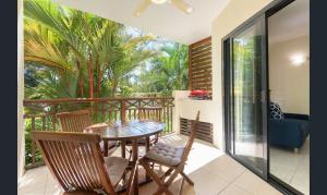 a balcony with a table and chairs on a deck at Charming 1 bedroom Apt - Close to Town & Beach in Port Douglas