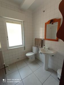 La salle de bains blanche est pourvue de toilettes et d'un lavabo. dans l'établissement Casa sella Asturias, à Arriondas