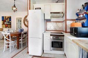 einen weißen Kühlschrank in einer Küche mit einem Tisch in der Unterkunft Magnifico piso en la playa in El Puerto de Santa María