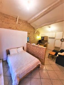 a bedroom with a bed and a brick wall at Le Cocoon avec parking gratuit in Cuisery