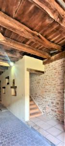 a room with a brick wall and wooden ceilings at Le Cocoon avec parking gratuit in Cuisery