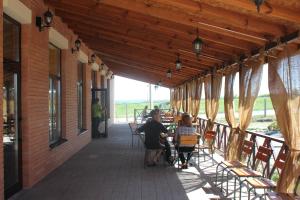 um grupo de pessoas sentadas numa mesa num alpendre em Kazanok em Svitlogirske