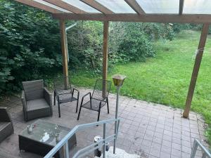un patio con sillas, una mesa y una pérgola en M & B Home 2, en Núremberg