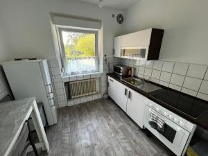 uma cozinha com electrodomésticos brancos e uma janela em M & B Home 2 em Nurembergue