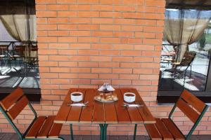 a wooden table with two chairs and a brick wall at Kazanok in Svitlohirske +23 photos