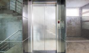 a metal elevator in a room with a staircase at Treebo Trend Trinetar International in Jammu