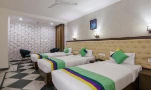 una habitación de hotel con 4 camas en una habitación en Treebo Trend Trinetar International, en Jammu