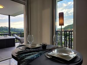 Altenbeken的住宿－Egge Resort 7b mit Whirpool u Sauna，一张带玻璃杯和盘子的餐桌,享有阳台的景色
