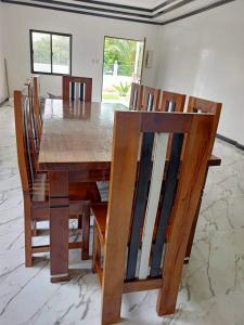 a dining room table and chairs with a wooden table and chairsearcher at Capinahan Guest House 