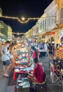 a group of people at a street market at night at Rabbitel Phuket in Phuket Town