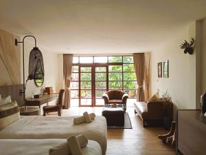 a bedroom with a large bed and a desk and chairs at Issara Boutique Winery Hotel in Muak Lek District