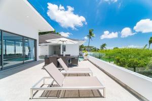 an outdoor patio of a house with chairs and an umbrella at Nastha Villa 3 bedrooms in Koh Samui 