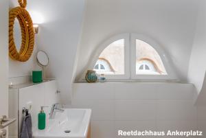 a bathroom with a sink and a window at Reetidyll am Haff in Pepelow