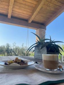 a table with a plate of food and a cup of coffee at Bnb Verdeolivo in Coriano