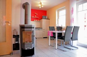 cocina con chimenea, mesa y sillas en Ferienwohnungen Appartements - Ferienhaus Müritzlust, en Marienfelde