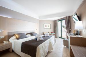 a hotel room with a large bed and a television at Hipotels Natura Palace Adults Only in Playa Blanca