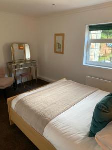 a bedroom with a bed and a mirror and a desk at The Apartment, Bridge House in Laxey