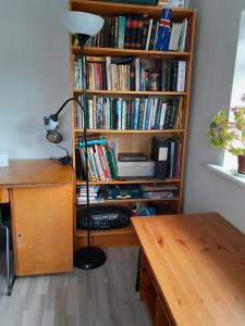 a book shelf filled with books next to a desk at Kyrrðarstaður in Selfoss