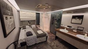 a bedroom with a bed and a bathroom with a sink at BeautyD GREY ROOM centrum Gullegem in Wevelgem