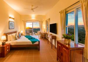 a bedroom with a bed and a balcony with a view at Sleeping Beauty by Nature Resorts and Stays in Coonoor