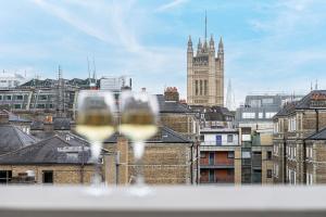 a view of a city with two glasses of wine at ALTIDO Luxury flats near Big Ben and London Eye in London