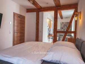 um quarto com uma cama e uma porta de madeira em Wundervolle Ferienwohnung - Zum Borkenkäfer 1 em Elbingerode