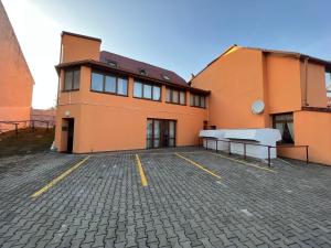 een oranje gebouw met banken op een parkeerplaats bij Helen Villa free parking in Prague in Praag