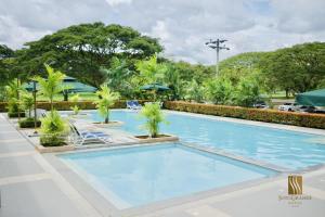 a large swimming pool with palm trees in a resort at Sotogrande Davao Hotel in Davao City