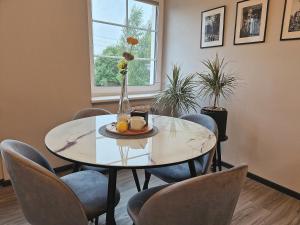 a dining room table with chairs and a vase with flowers at Seliu 25 Homestay Apartment poilsio namai in Šiauliai