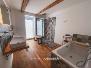uma casa de banho com uma banheira grande e um chuveiro em Wundervolle Ferienwohnung - Zum Borkenkäfer 1 em Elbingerode