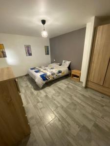 a bedroom with a bed and a wooden floor at appartement de charme proche de Moissac in Labastide-du-Temple