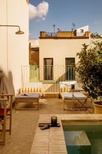 eine Dachterrasse mit einem Pool und einem Gebäude in der Unterkunft BOSCOS APARTMENTs in Sevilla