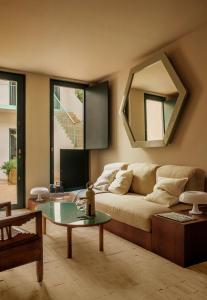 ein Wohnzimmer mit einem Sofa und einem Spiegel in der Unterkunft BOSCOS APARTMENTs in Sevilla