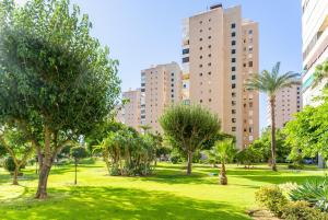 un parque con palmeras y edificios altos en Apartamento frente al mar TORRES DE PLAYAMAR, en Torremolinos