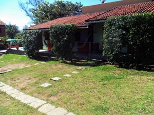 a house with ivy growing around it next to a yard at Pousada Viva Mar in Saquarema