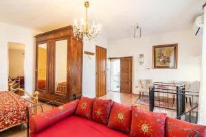 a living room with a red couch and a chandelier at Casa castello in Rocca Imperiale