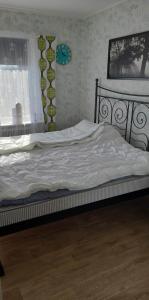 1 dormitorio con 1 cama con sábanas blancas y ventana en Villa Svalan, en Hällefors