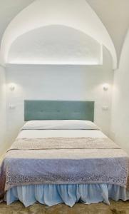 een slaapkamer met een groot bed met een blauw hoofdeinde bij Dimora le Picciose in Ostuni