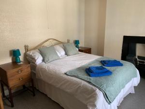 a bedroom with a bed with two blue towels on it at 17 Main Street in St Bees