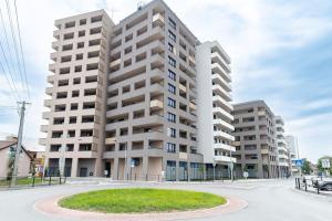um edifício de apartamentos com um círculo em frente em Apartmán Al-Park s private parking, 5 min pešo do centra em Košice
