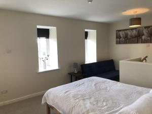 a bedroom with a bed and a blue couch at Amazing converted water tower! in Coulsdon