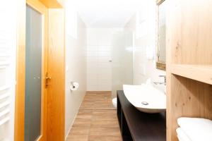 a white bathroom with a sink and a mirror at S'Matt 3 in Lingenau