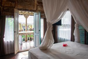um quarto com uma cama de dossel branco em Ubud Lestari Villa em Ubud