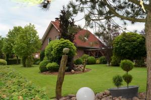 a house with a yard with a house with a fence at Ferienhaus Nikki 35528 in Uplengen