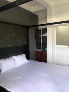 a bedroom with a large white bed and a window at Randi Apartments B&B in Boralesgamuwa