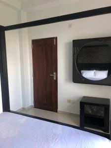 a bedroom with a bed and a wooden door at Randi Apartments B&B in Boralesgamuwa
