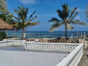 a view of the beach with palm trees and the ocean at Oluwa Seun Beach Cottages, Mtwapa in Mombasa